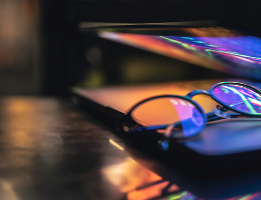 Notebook com óculos de grau apoiado